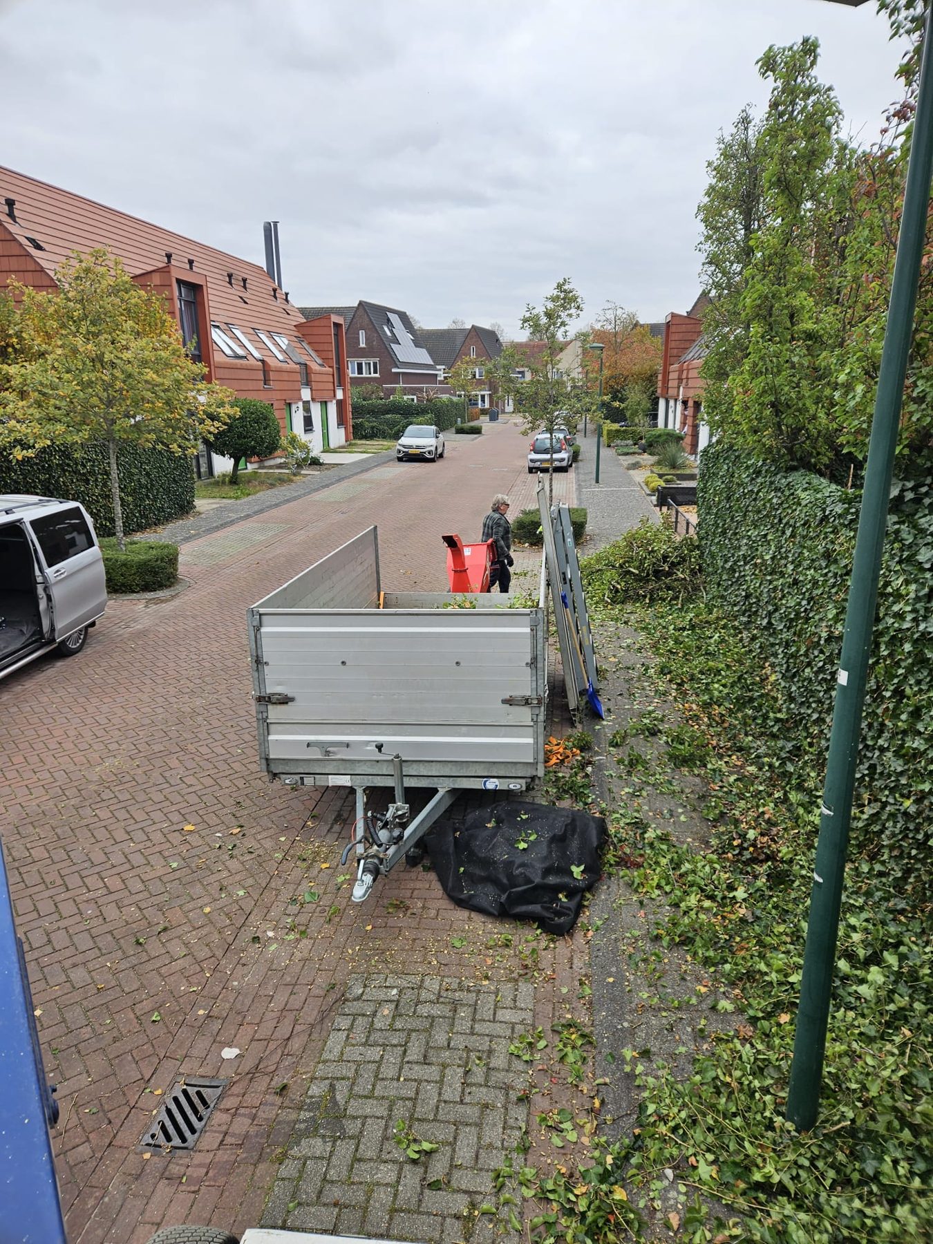 Rooiwerkzaamheden met kraanwagen in een woonstraat in Breda